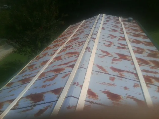 Rusted metal roof panels with new wood purlins before replacement — Storm Damage Roof Repair in Camden Point by Roofing Brothers
