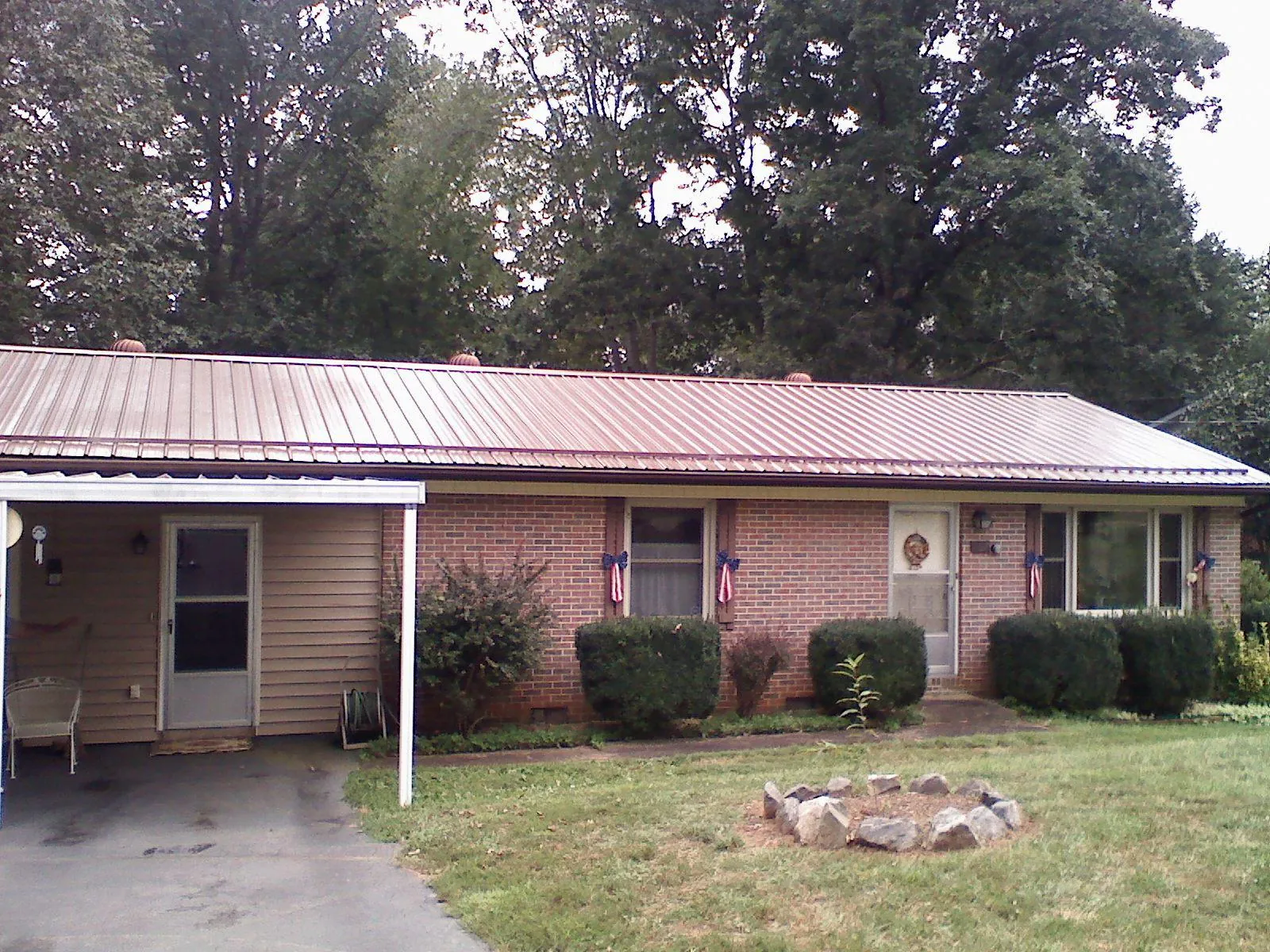Bronze metal roof and carport on a brick ranch home — Roof Repair work by our crew in Camden Point